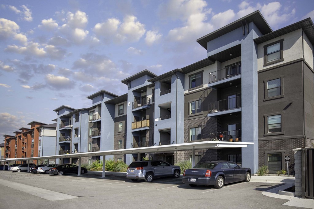 a rendering of an apartment building with cars parked in front of it