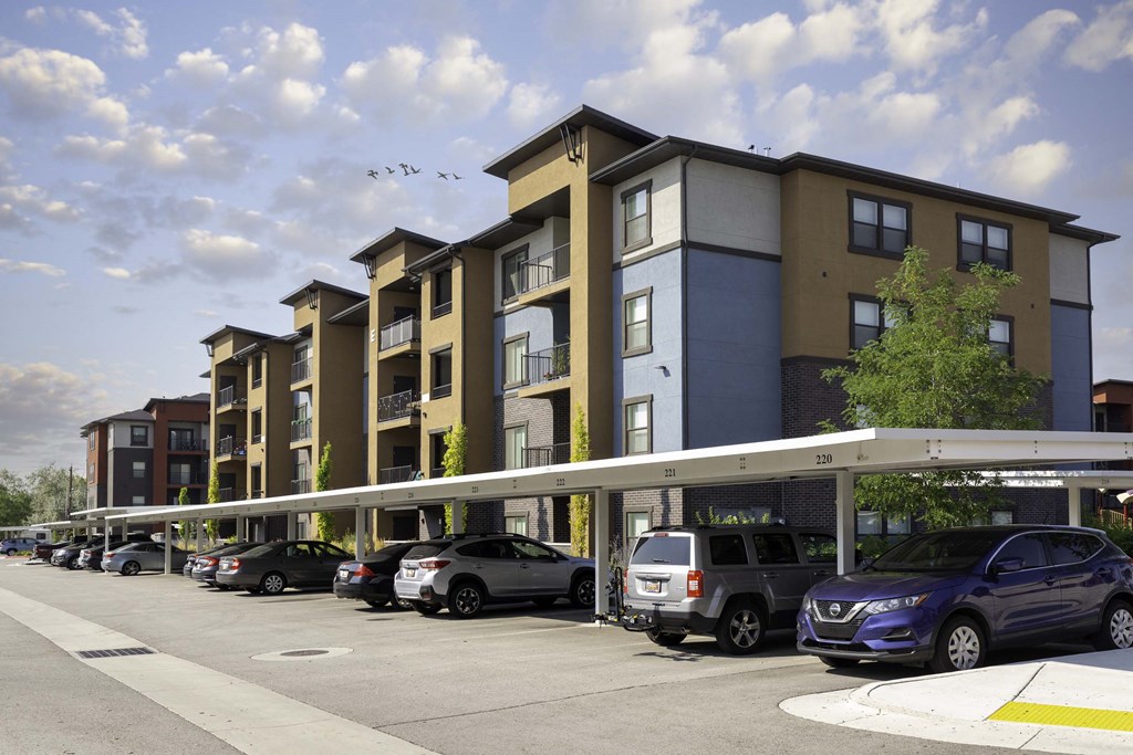 a rendering of an apartment building with cars parked in front of it
