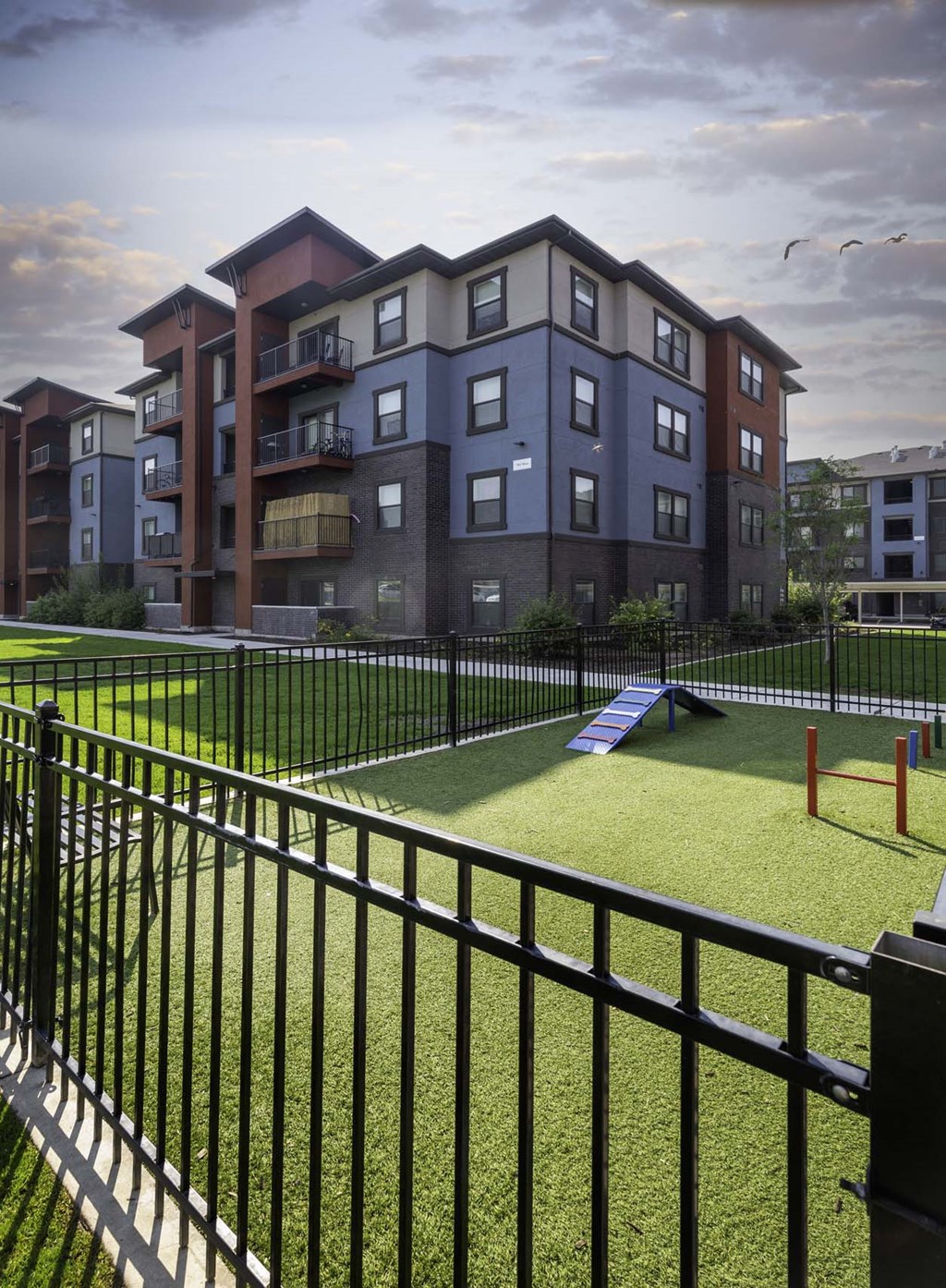 a rendering of an apartment building with a playground in the foreground