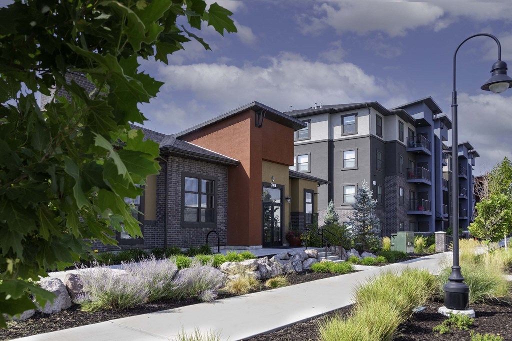 a rendering of an apartment building with a sidewalk in front of it
