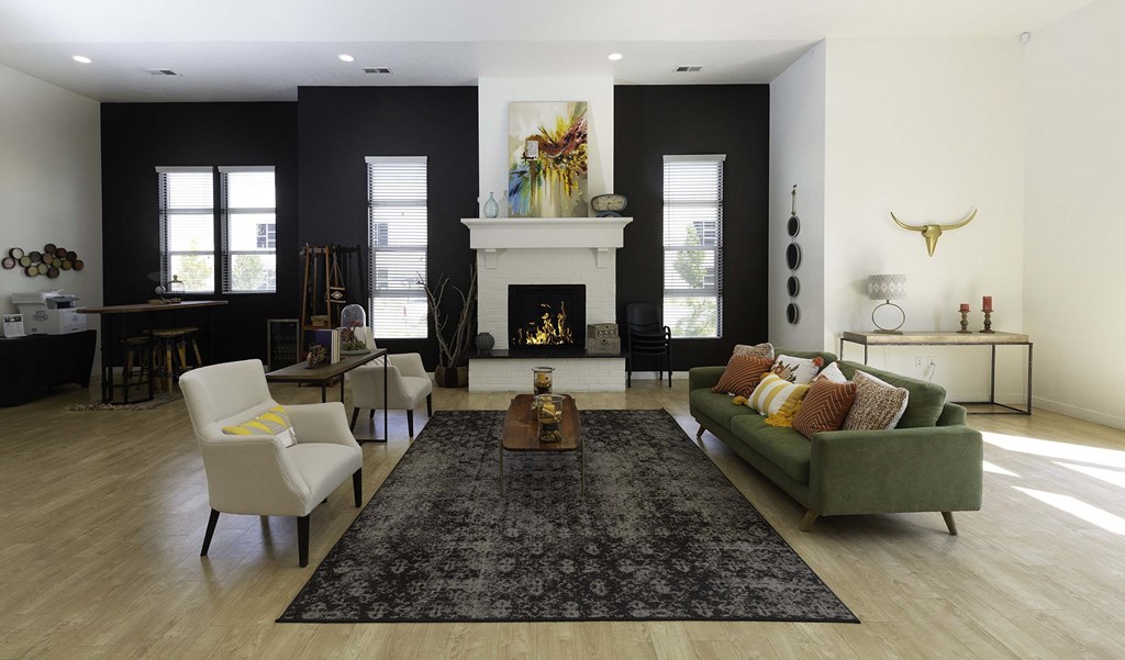 a living room with a green couch and two white chairs in front of a fireplace