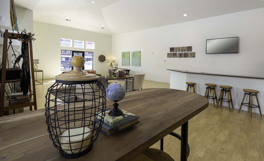 a large room with a wooden table and a black cage with a globe on top of it