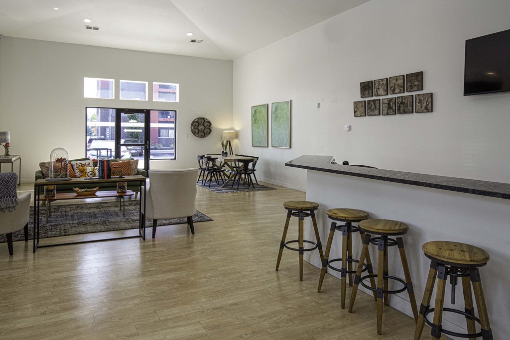 a living room with a bar and a dining room in the background