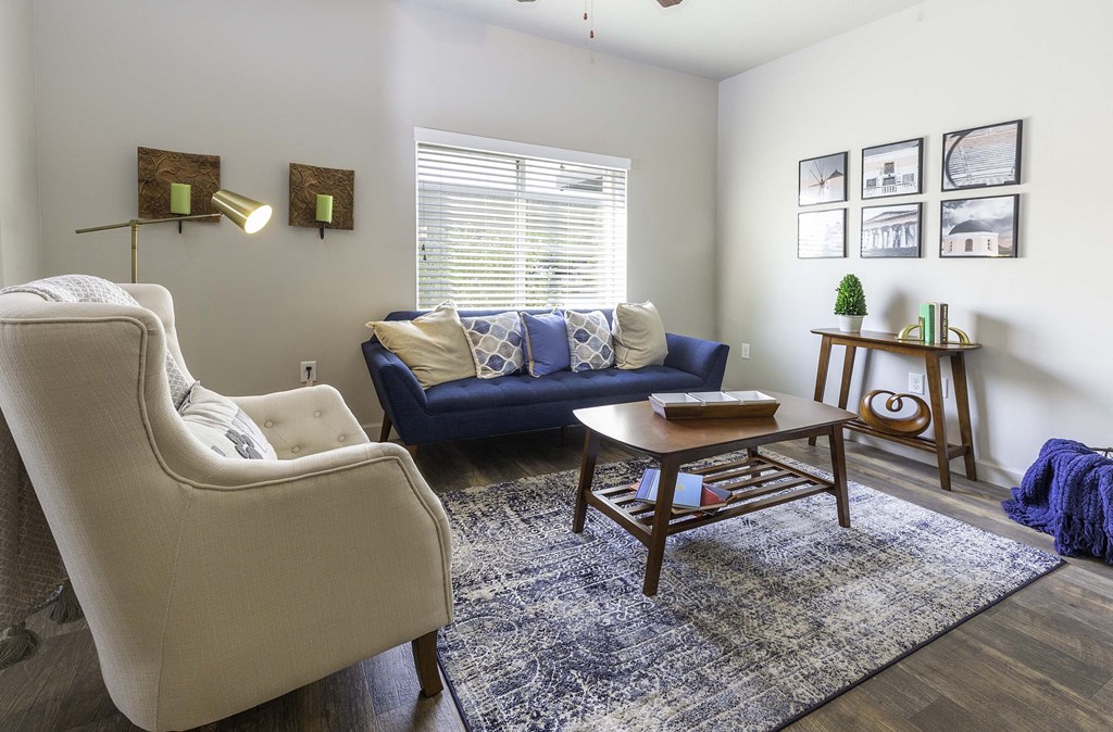 a living room with a blue couch and two white chairs