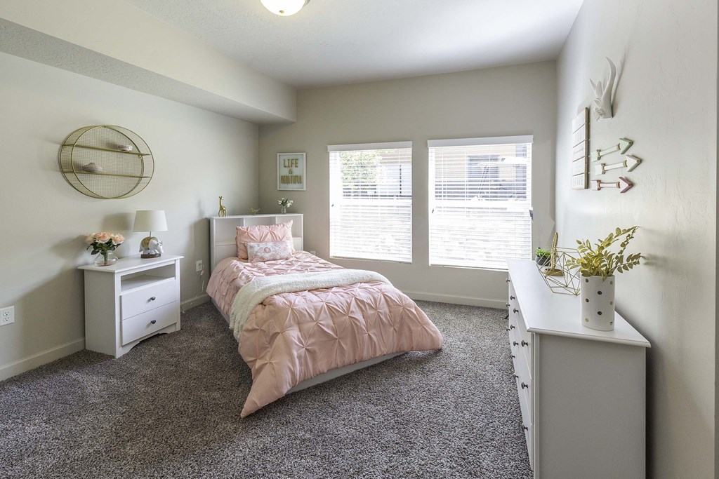 a bedroom with a bed and two windows