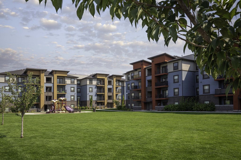 picture of an apartment building with a playground in the foreground