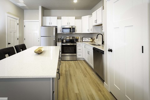 a large kitchen with white cabinets and stainless steel appliances