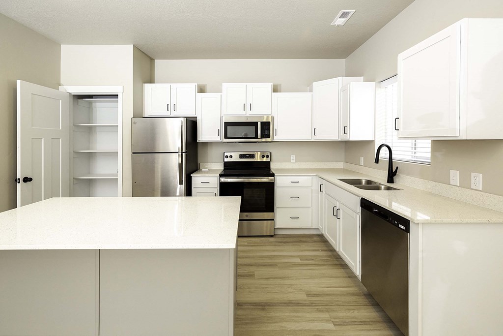 a kitchen with white cabinets and stainless steel appliances