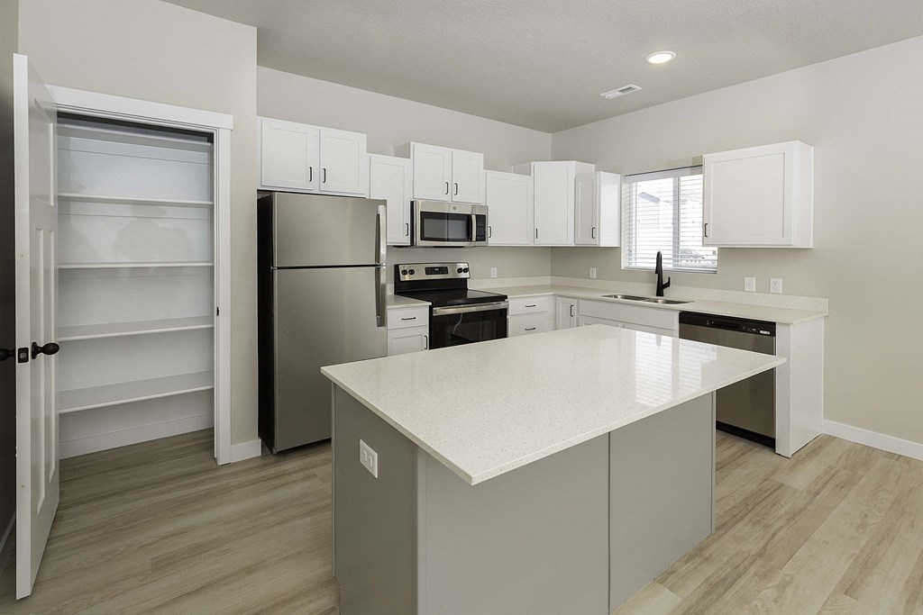 a kitchen with white cabinets and stainless steel appliances