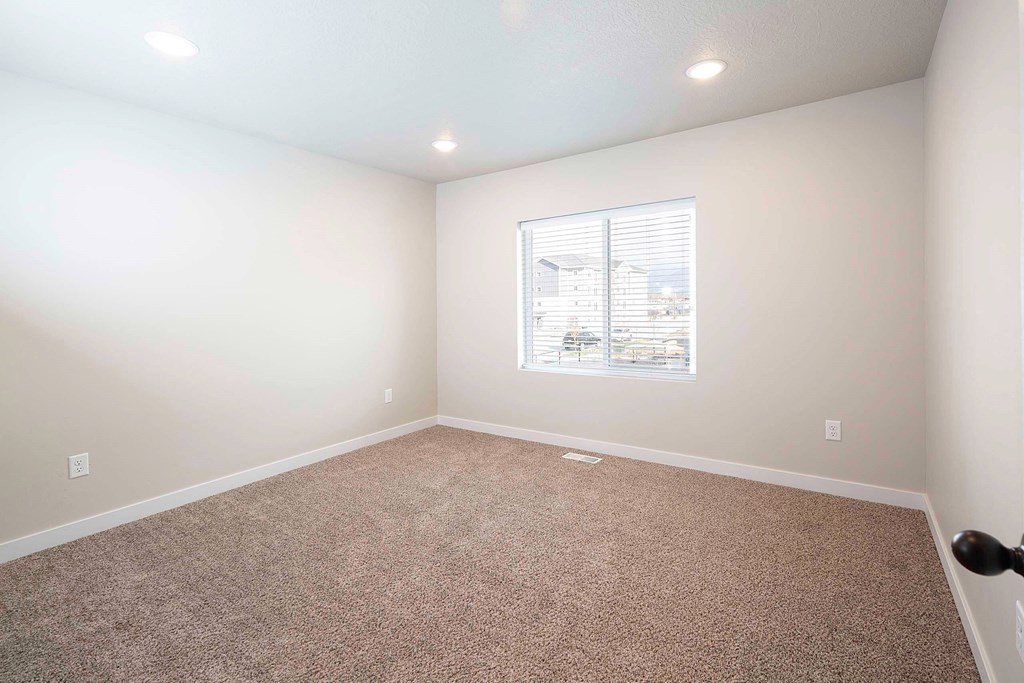 a bedroom with white walls and a window