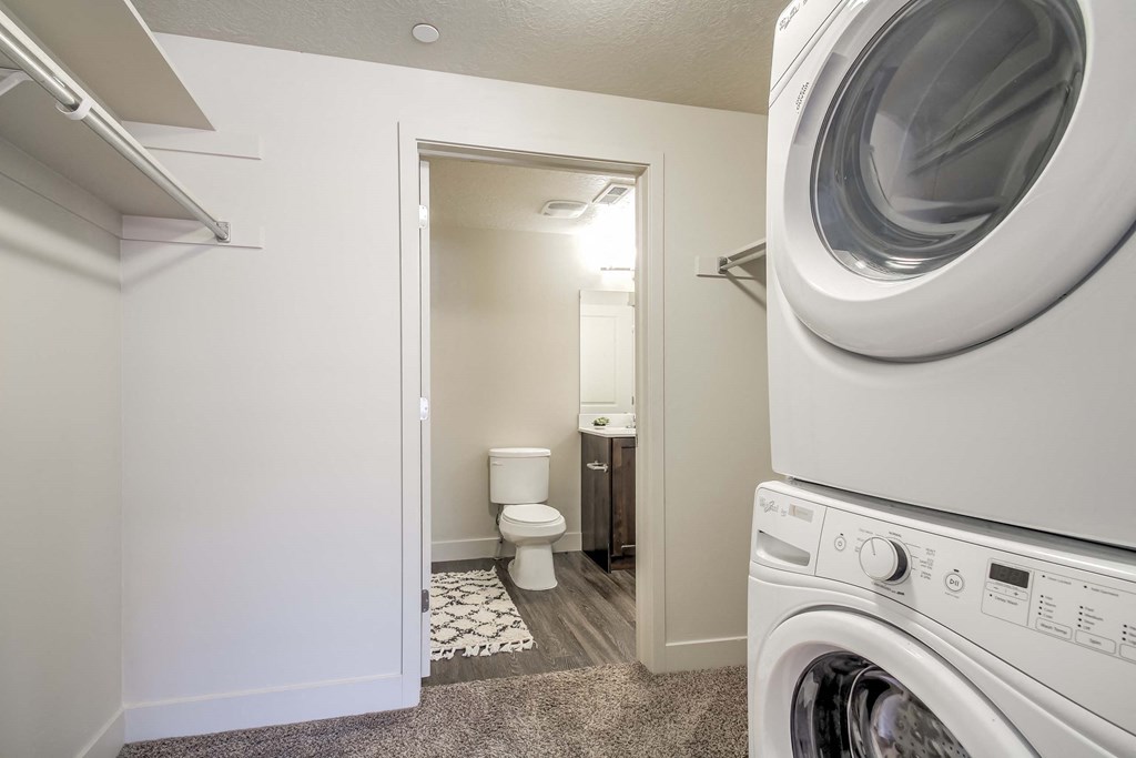 a washer and dryer in a bathroom with a toilet