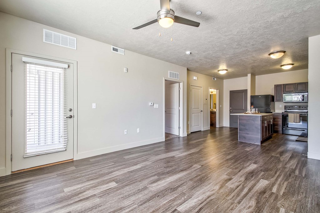 a living room and kitchen area with a ceiling fan