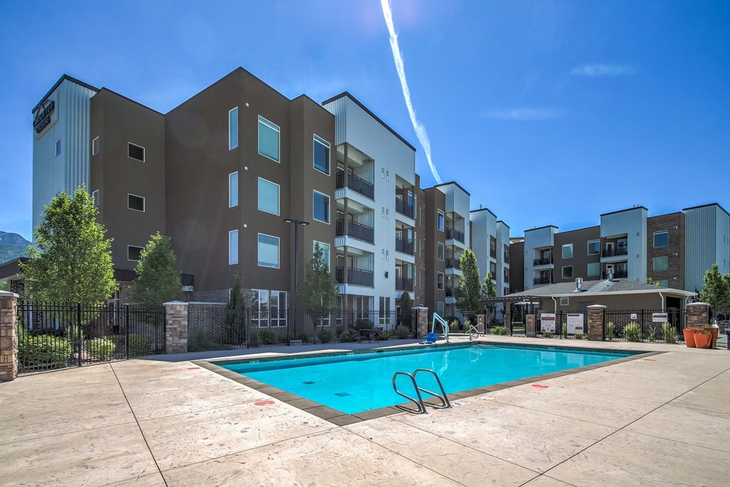an outdoor swimming pool with an apartment building in the background