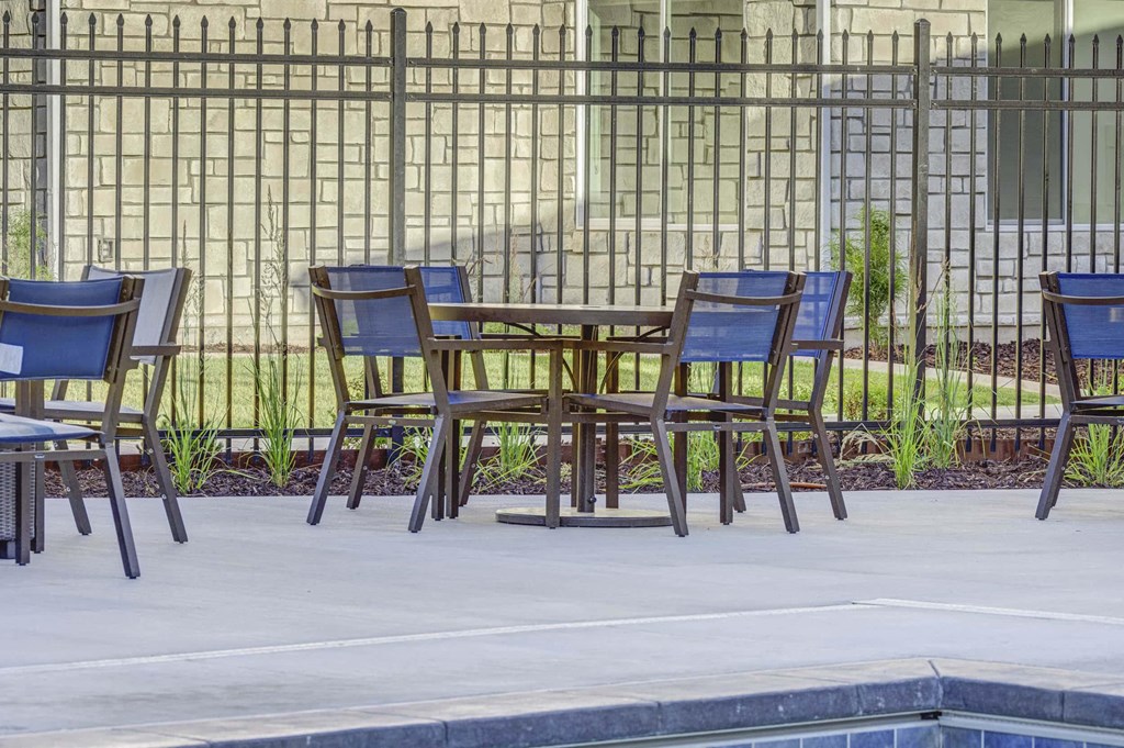 a group of chairs around a table next to a pool