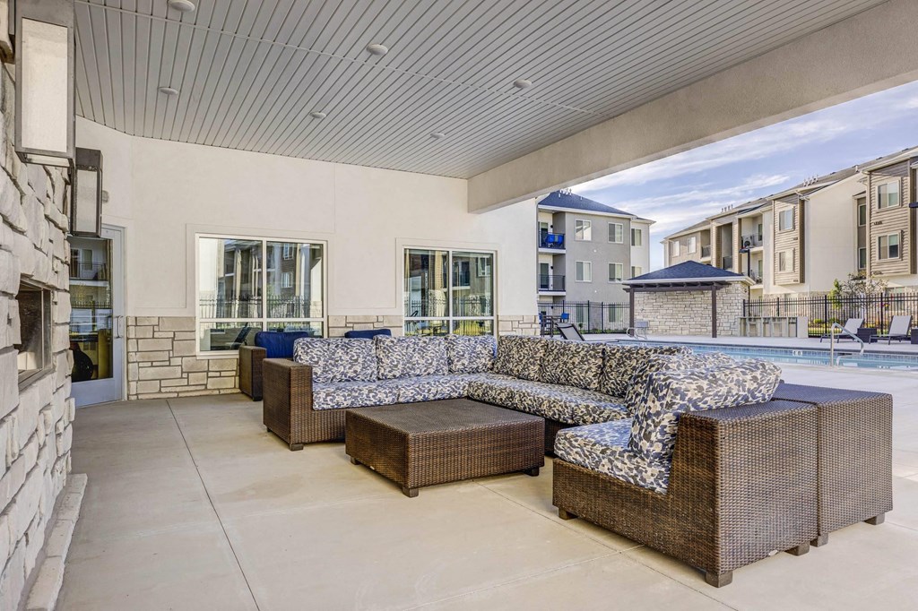 a living room with couches and a table next to a pool