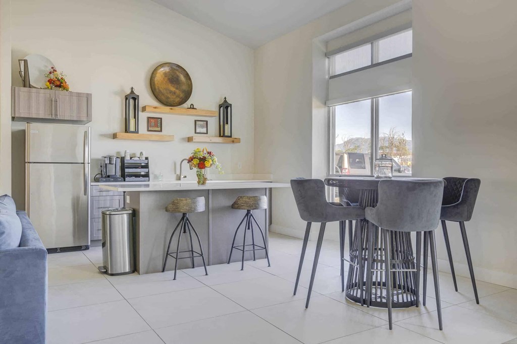 a kitchen with bar stools and a counter with a sink
