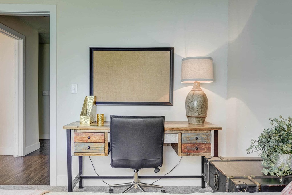 a desk with a chair and a lamp in a living room