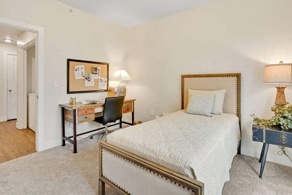 a bedroom with a bed and a desk