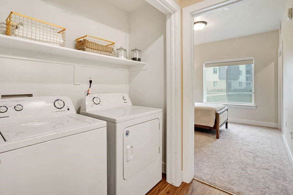 a laundry room with a washer and dryer next to a window