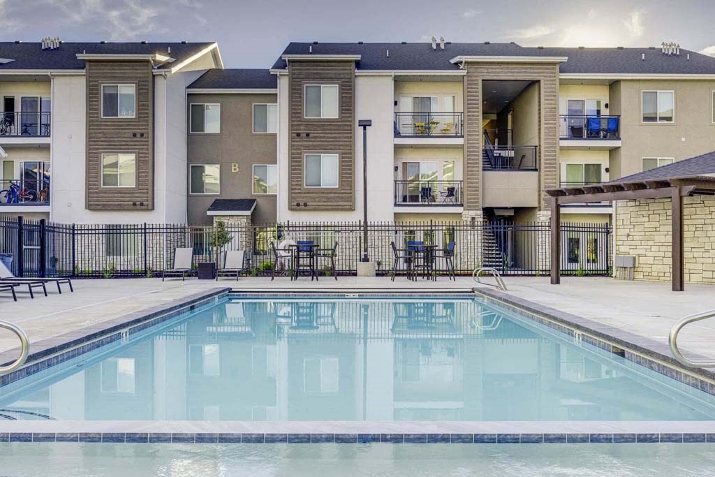 A swimming pool in front of apartment buildings.