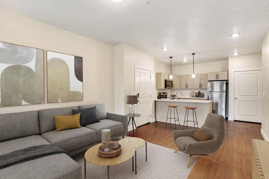 A living room with a grey couch, a coffee table, and a painting on the wall.