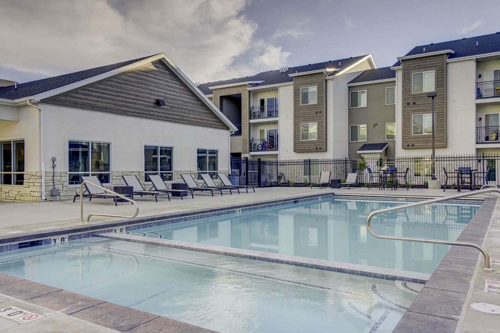 A swimming pool in front of apartment buildings.