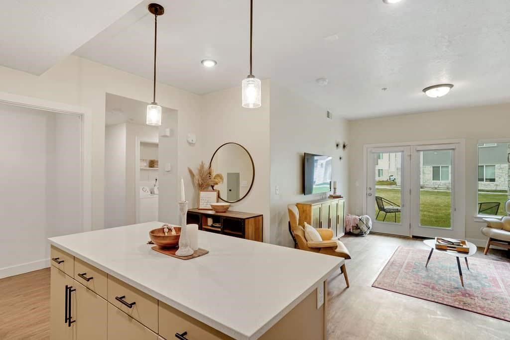 A modern kitchen with a white countertop and wooden cabinets.