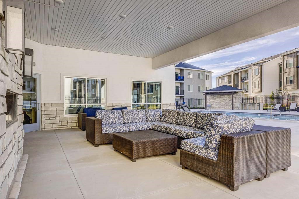 A modern outdoor seating area with a large couch and a coffee table.