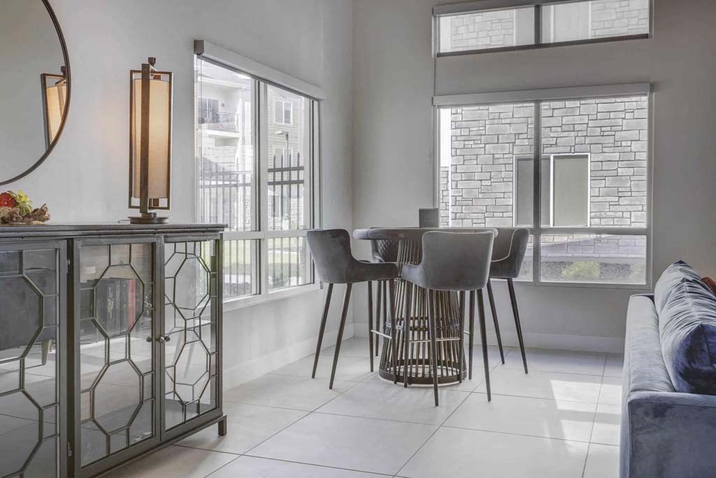 A modern living room with a glass table and chairs.