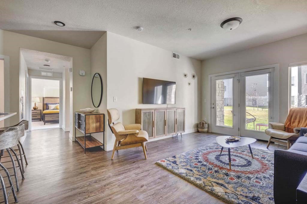 A living room with a rug and a chair.