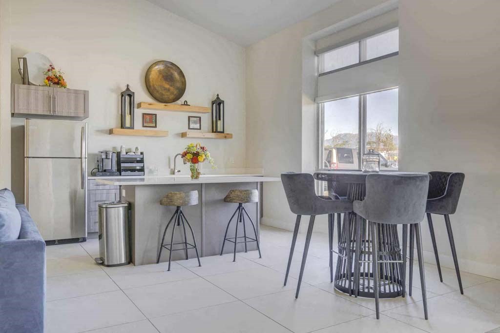 A kitchen with a grey table and chairs.