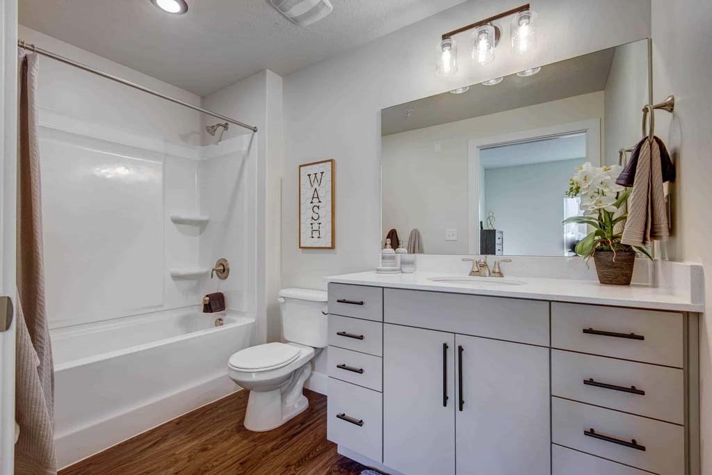 A white bathroom with a toilet, sink, and bathtub.