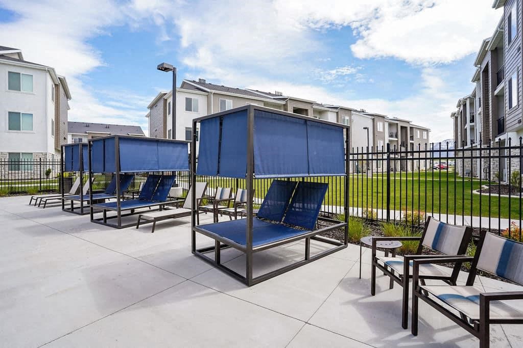 A row of blue sun loungers are on a patio.