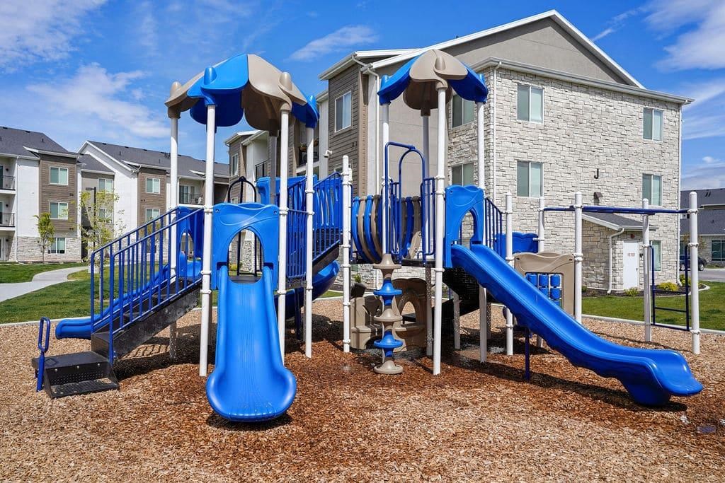 A playground with a blue slide and a brown slide.