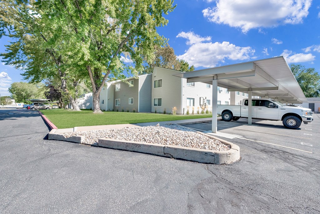 A white car is parked under a white canopy.