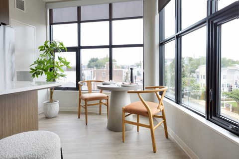 a dining room with a table and chairs in front of a window