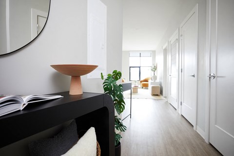 a black desk with a wooden bowl on top of it and a green plant next to it