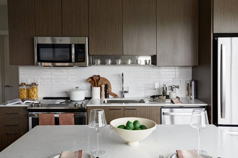 a kitchen with a white counter top and a bowl of fruit on it