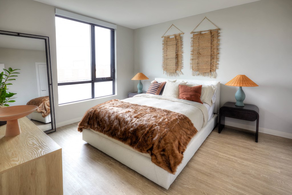 a bedroom with white walls and hardwood flooring