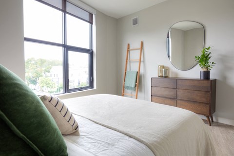 a bedroom with a bed and a dresser with a mirror