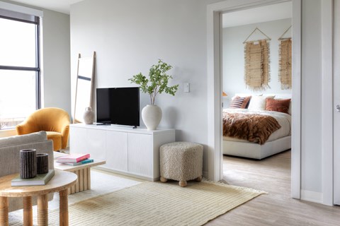 a living room with a bedroom in the background