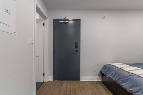 A bedroom with a bed and a black door.