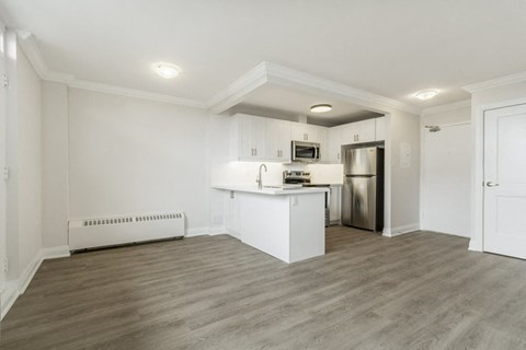 A kitchen with white cabinets and a stainless steel refrigerator.