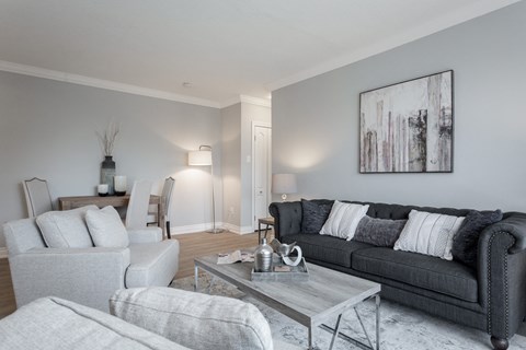 A modern living room with a grey couch and a coffee table.