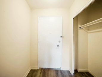 A white door is in a room with a wooden floor.