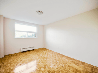 A room with a window and a radiator on the floor.
