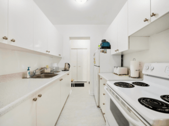 A white kitchen with a stove and sink.