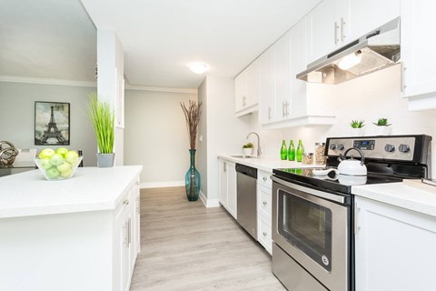A kitchen with white cabinets and a stainless steel oven.