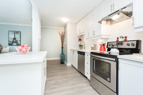 A modern kitchen with white cabinets and a black stove top oven.
