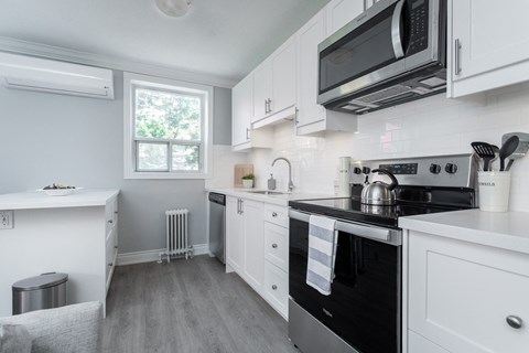 A kitchen with white cabinets and a black stove top oven.